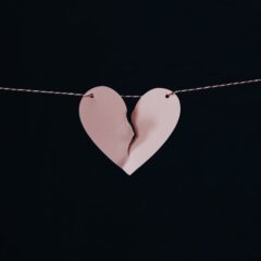 Ripped pink paper heart on a wire.