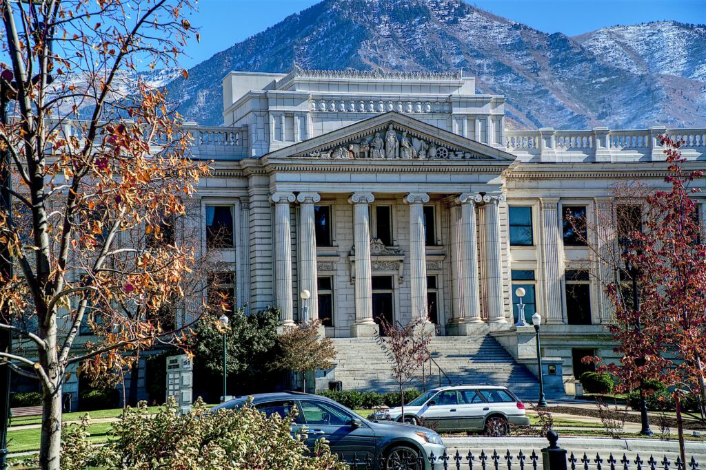 White Courthouse with Tall Multiple Pillars in the front with a Mountain backdrop; A courtroom where an Underage Baby DUI prosecution may take place