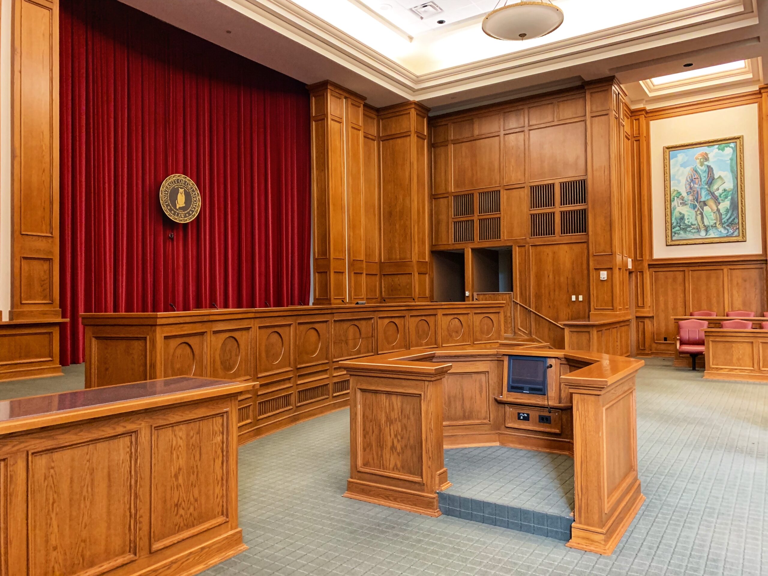 Old Style Courtroom with brown desks and a red backdrop