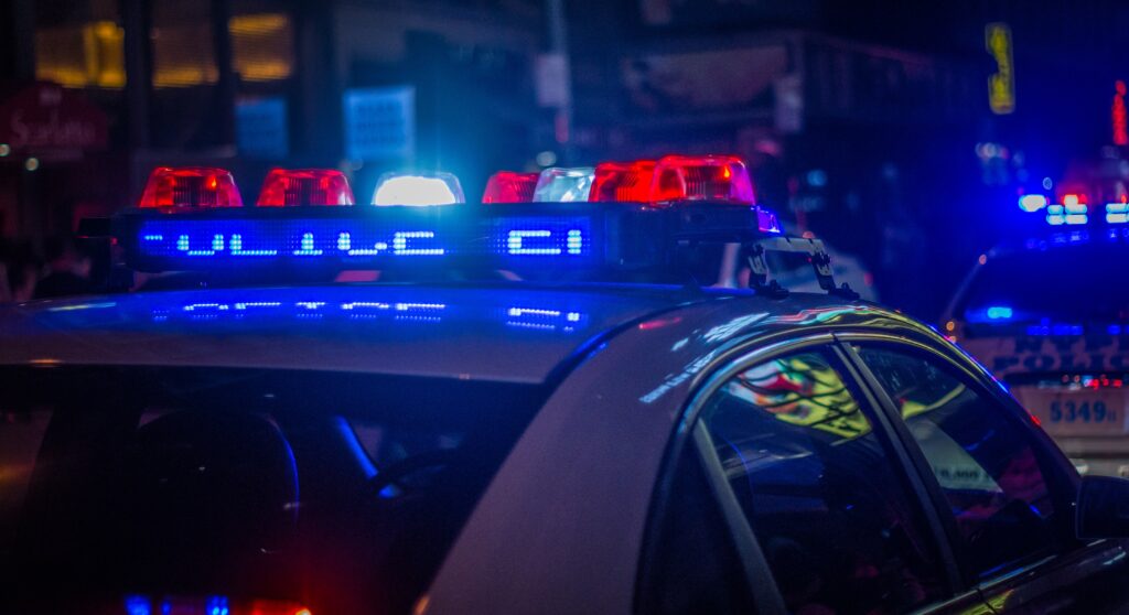 Police Car Close up of cab from passenger side rear with overhead red and blue emergency lights activated