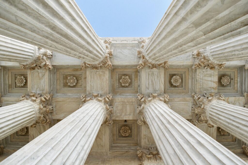 Looking up at ceiling of white courthouse in the middle of 4 pillars where a conviction may be set-aside